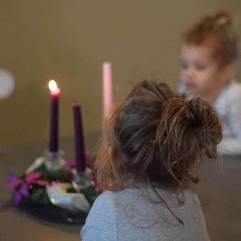 children looking at lit up advent wreath