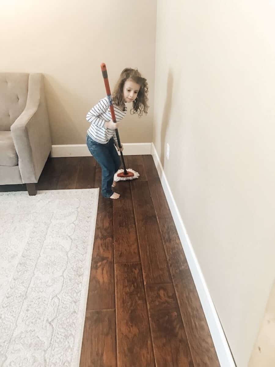 child working on chores and cleaning the floor 