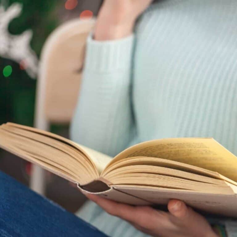 lady reading bible with christmas tree in background