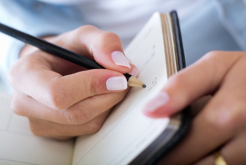 lady holding a notebook and pencil