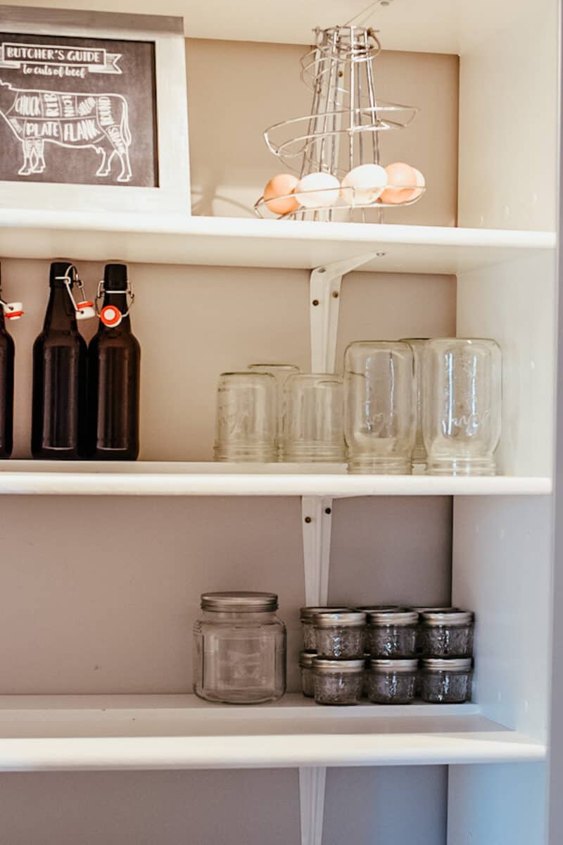 shelving in farmhouse pantry with empty mason jars