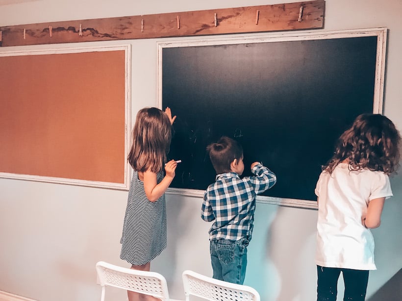 children writing on a chalkboard 