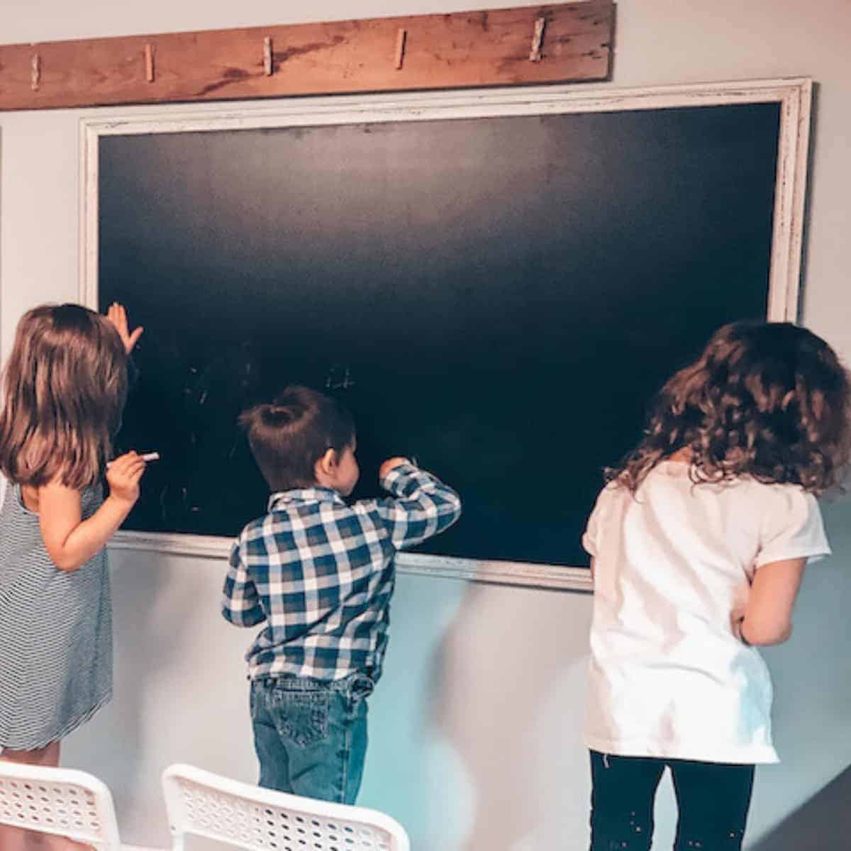 children writing on a chalkboard