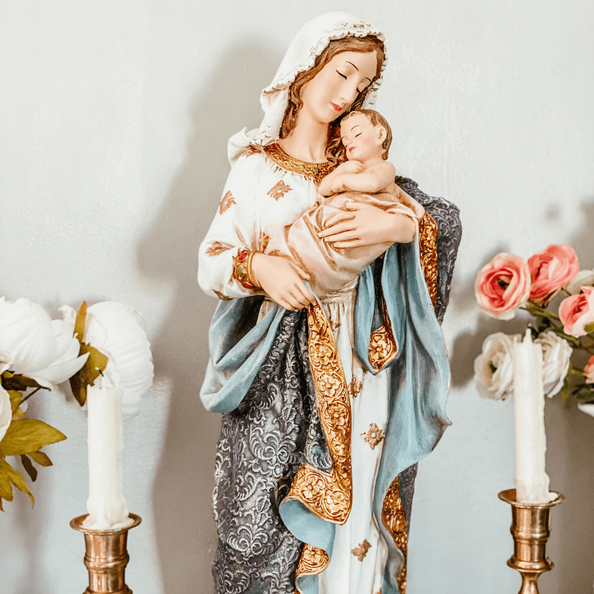 statue of blessed mother with two blessed candles