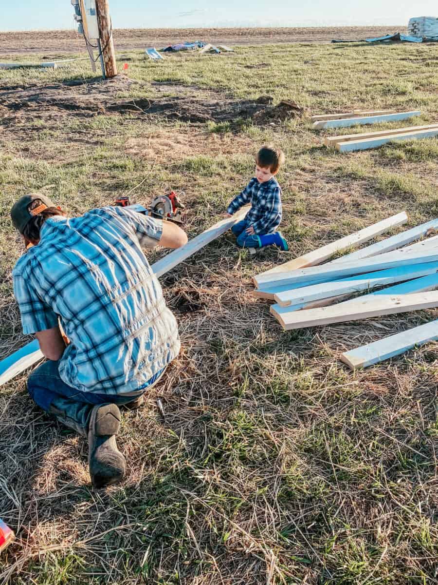 father and son building with wood outside 