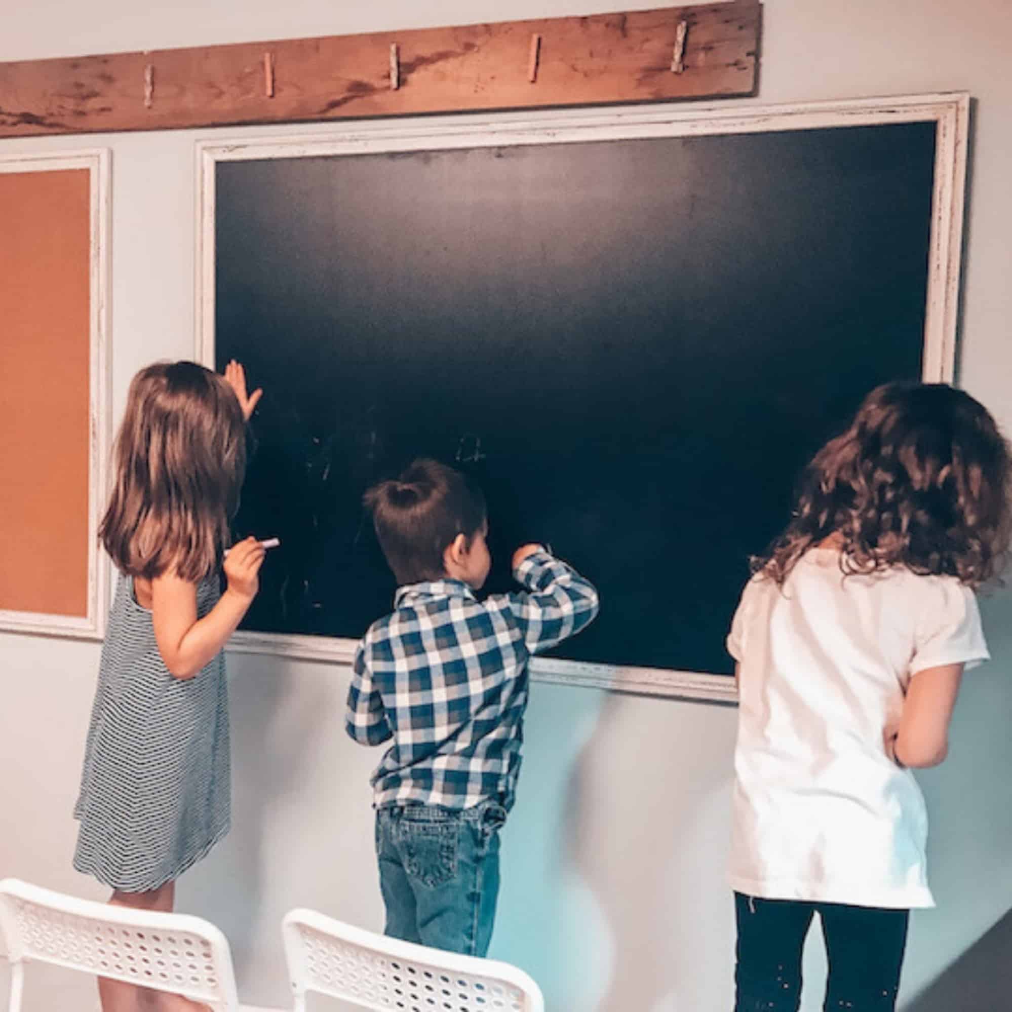 children writing on a chalk board in the classroom