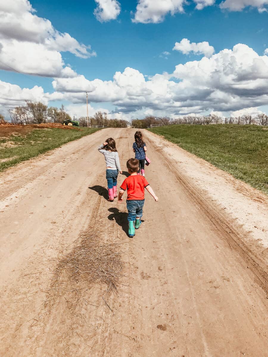 kids walking on a dirt road in the country