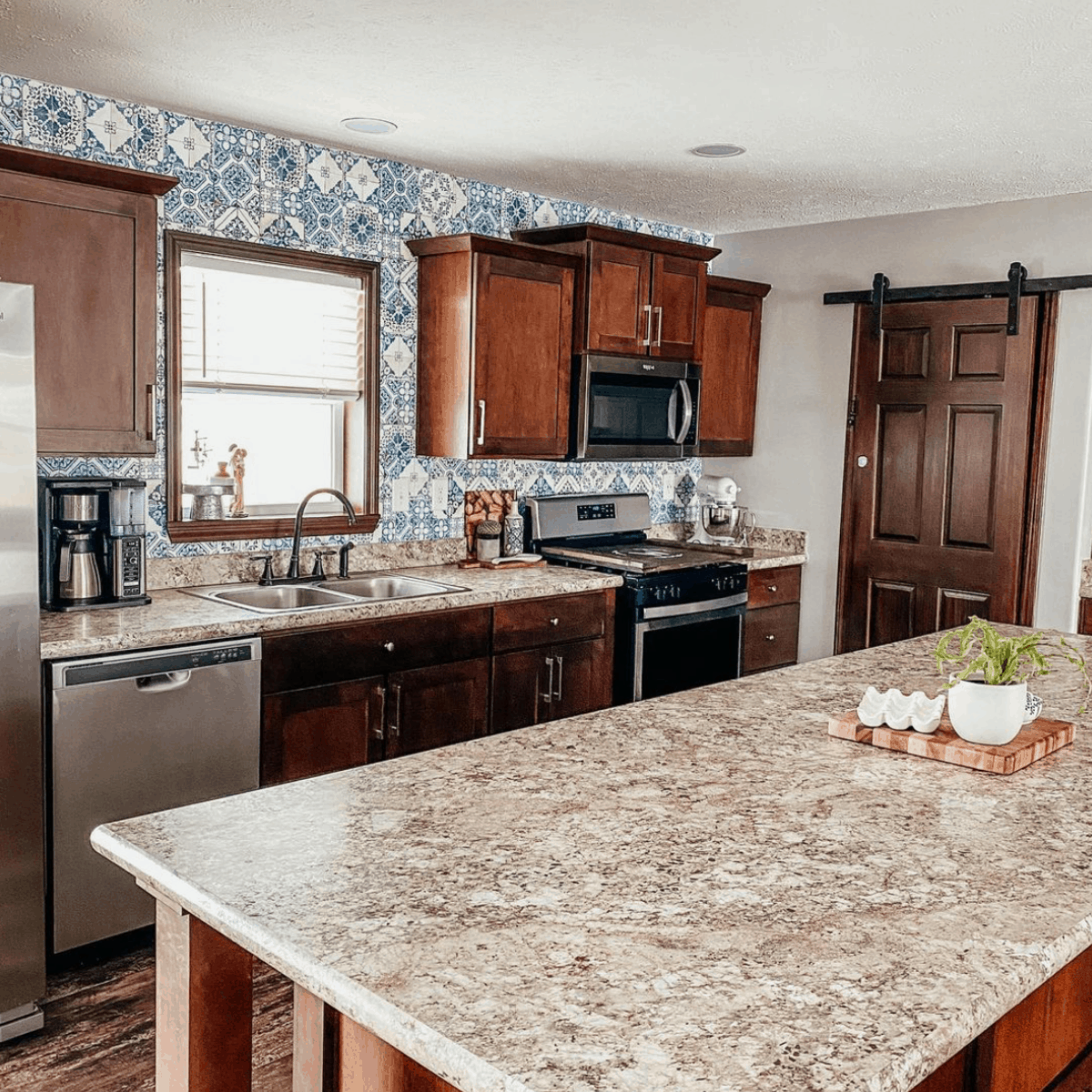 clean kitchen and island with houseplant