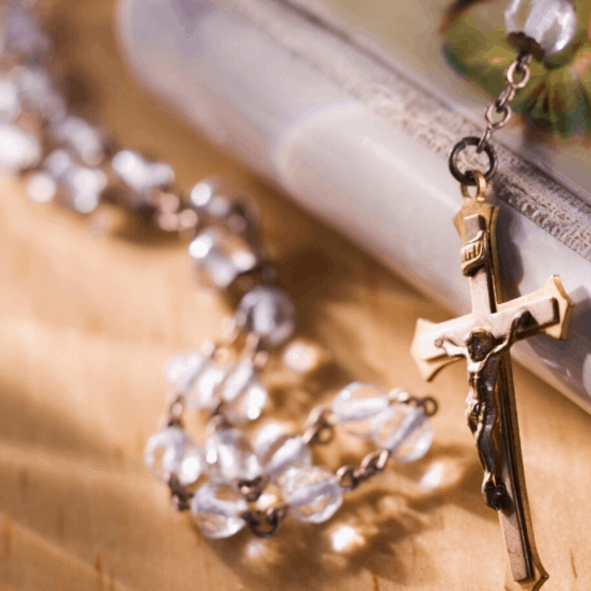 clear rosary laying on a prayer book