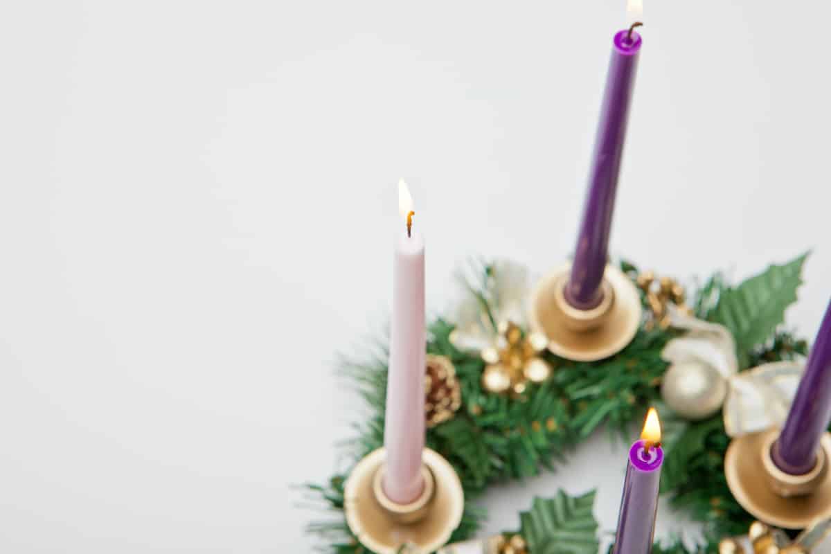 partial view of advent wreath with only 3 of the candles in focus