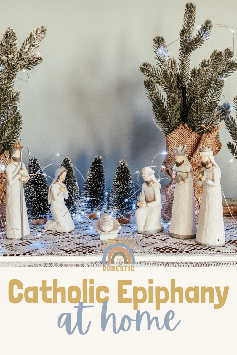 small nativity scene with white statues and trees in the background