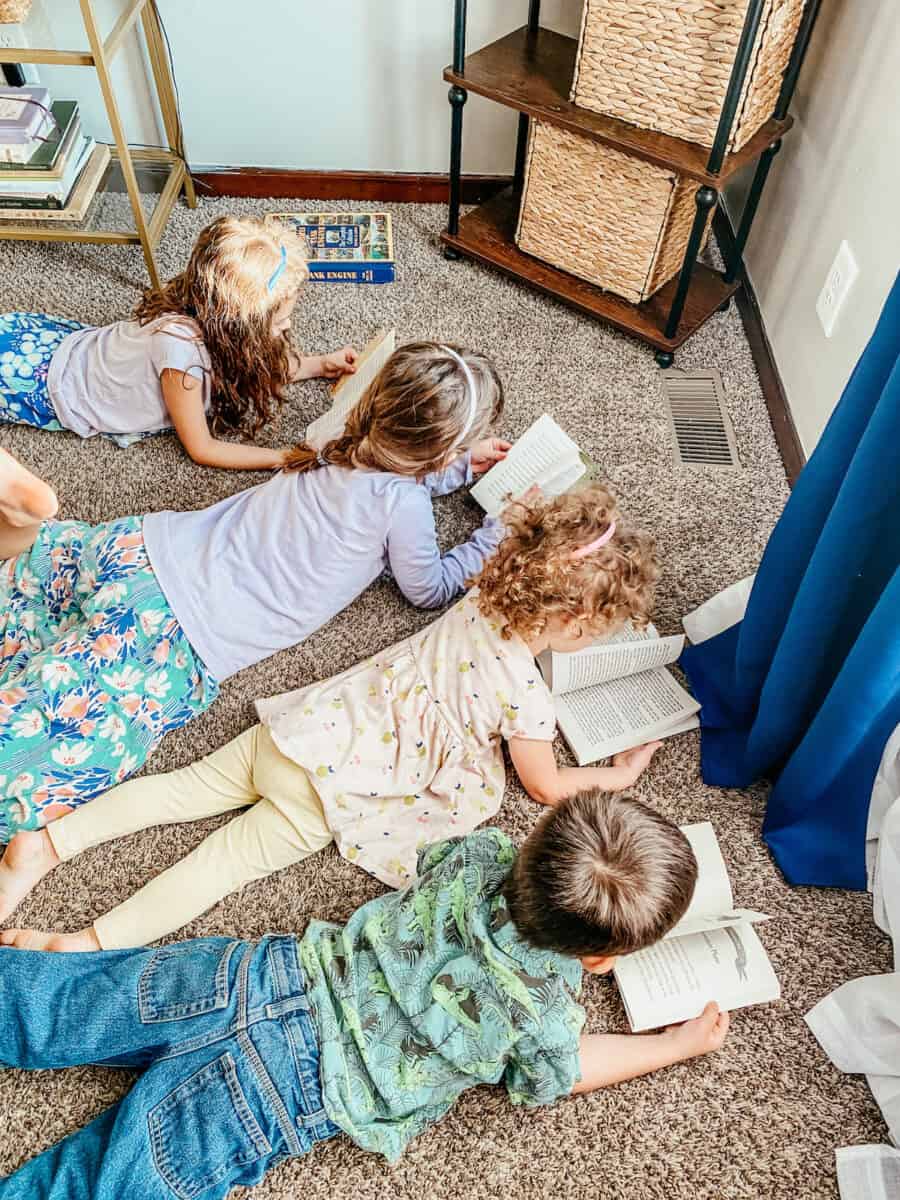 children laying on carpet and reading books