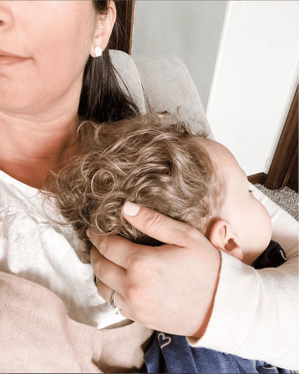 mom holding a toddler while sitting in a chair