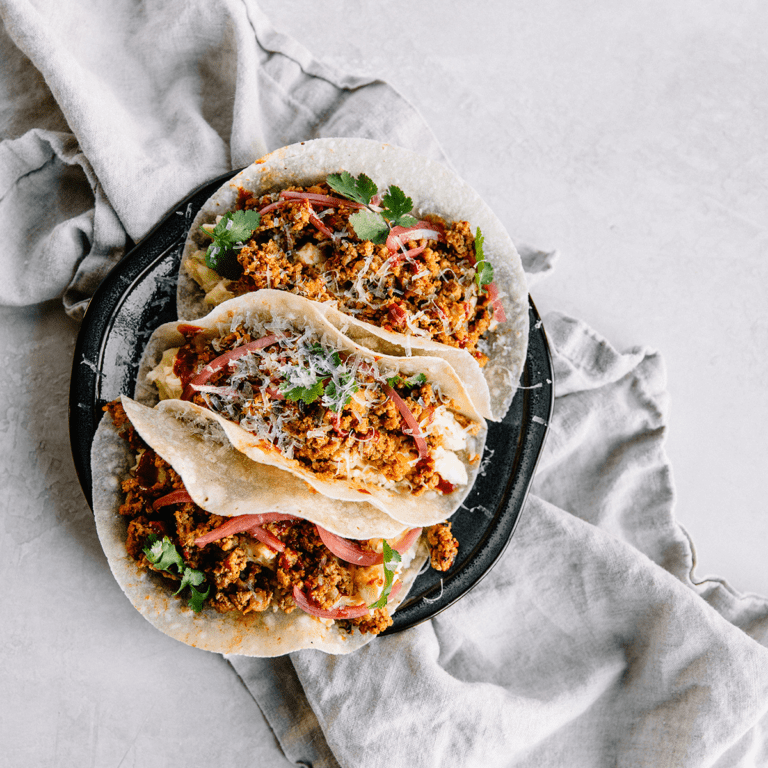 black plate of tacos with clean eating ground beef recipes and a light gray linen tea towel