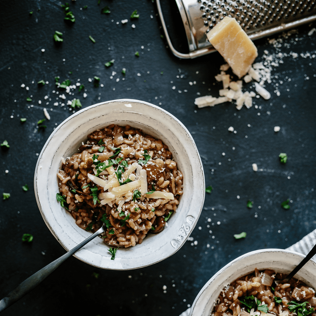 farro risotto in white bowls with fresh shredded parmesan cheese