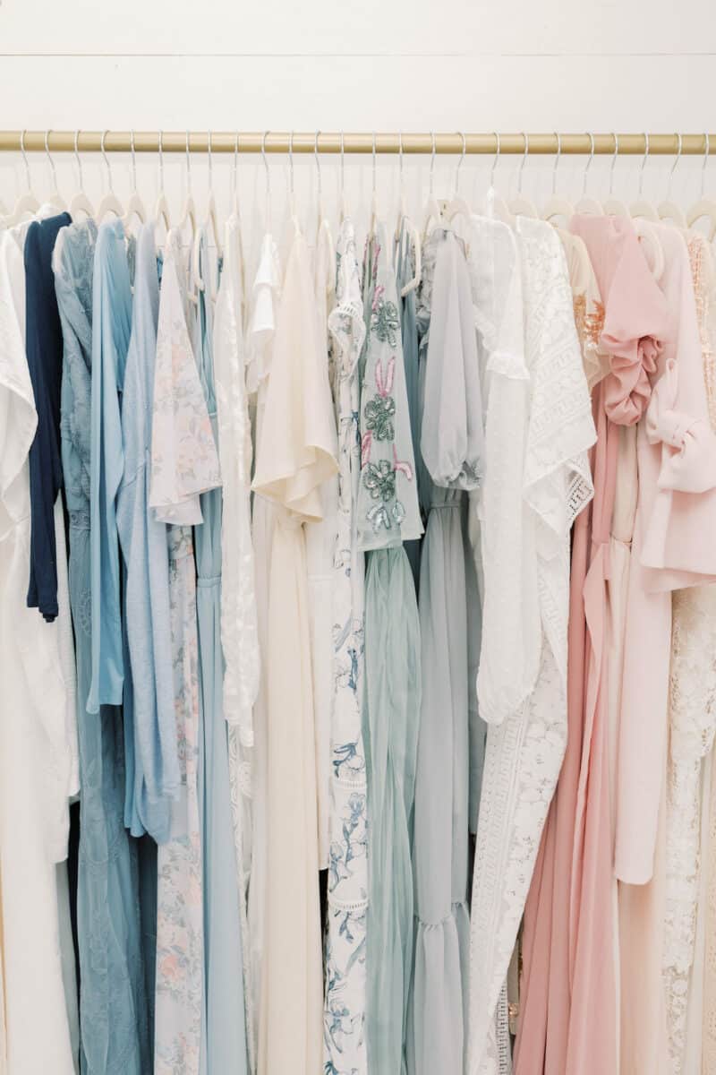 pastel colored dresses hanging in closet.