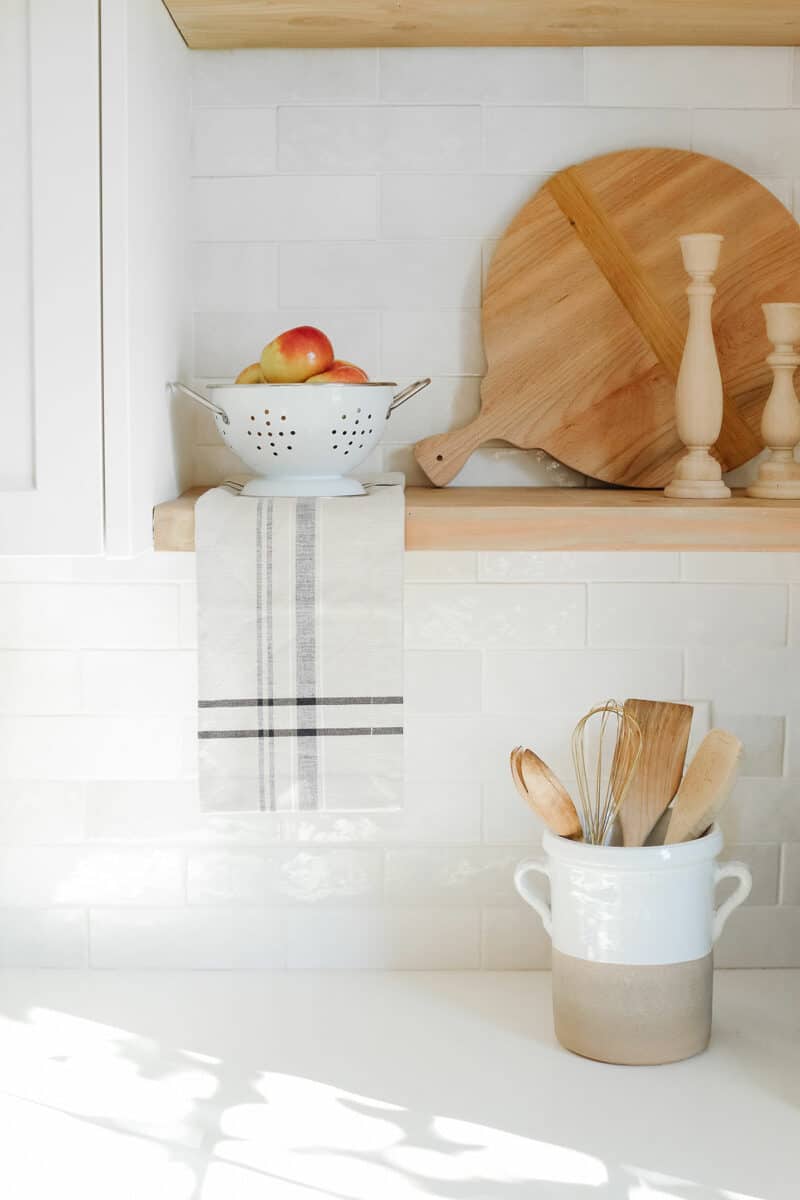 kitchen shelves with linen and strainer with apples.