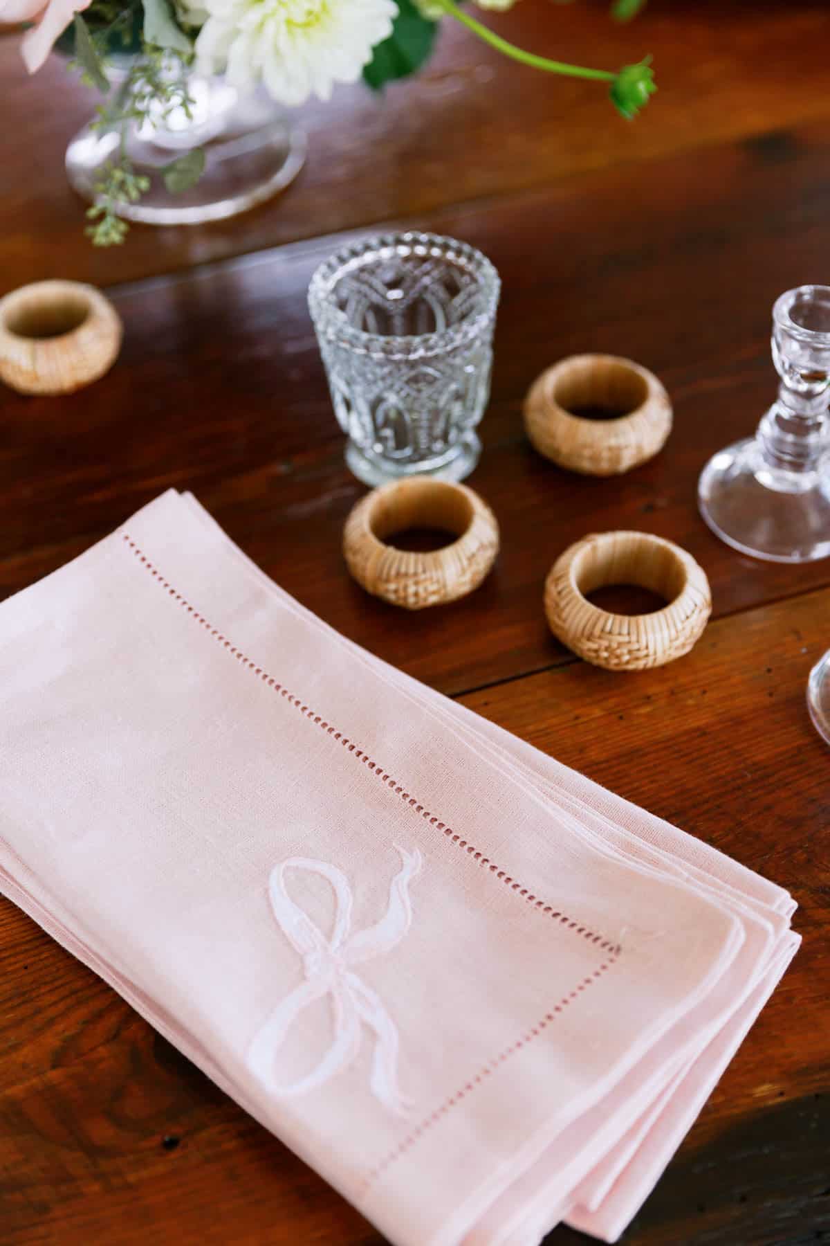 cloth napkins and wood napkin rings on wooden tabletop. 