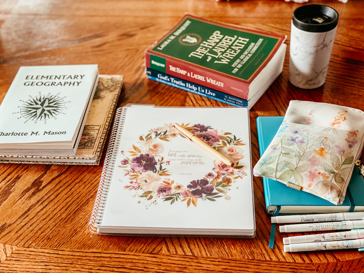 teacher planner, pre reading notebook, highlighters, and school books on a table top.