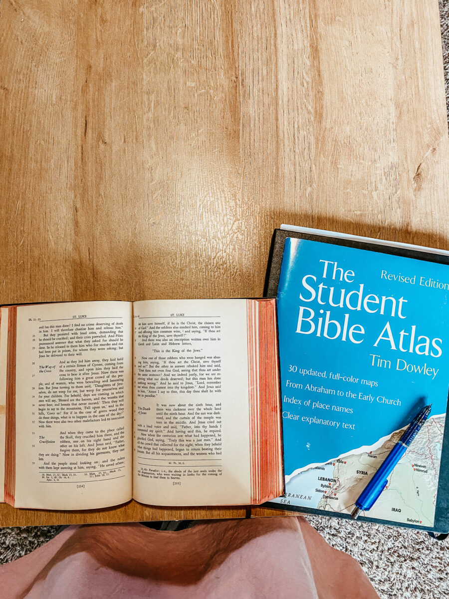 New Testament bible with a student bible atlas on a table top. 