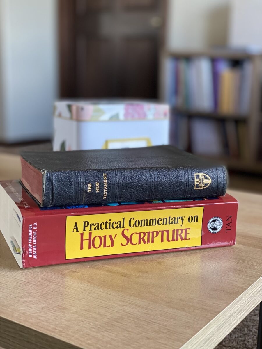 stack of bible and bible commentary books on a table. 