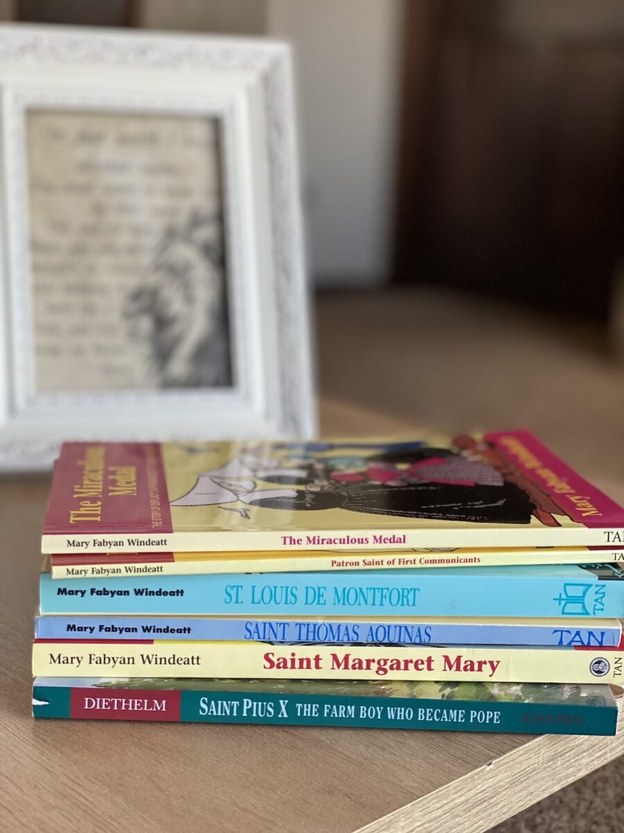 saint books stacked on a table. 