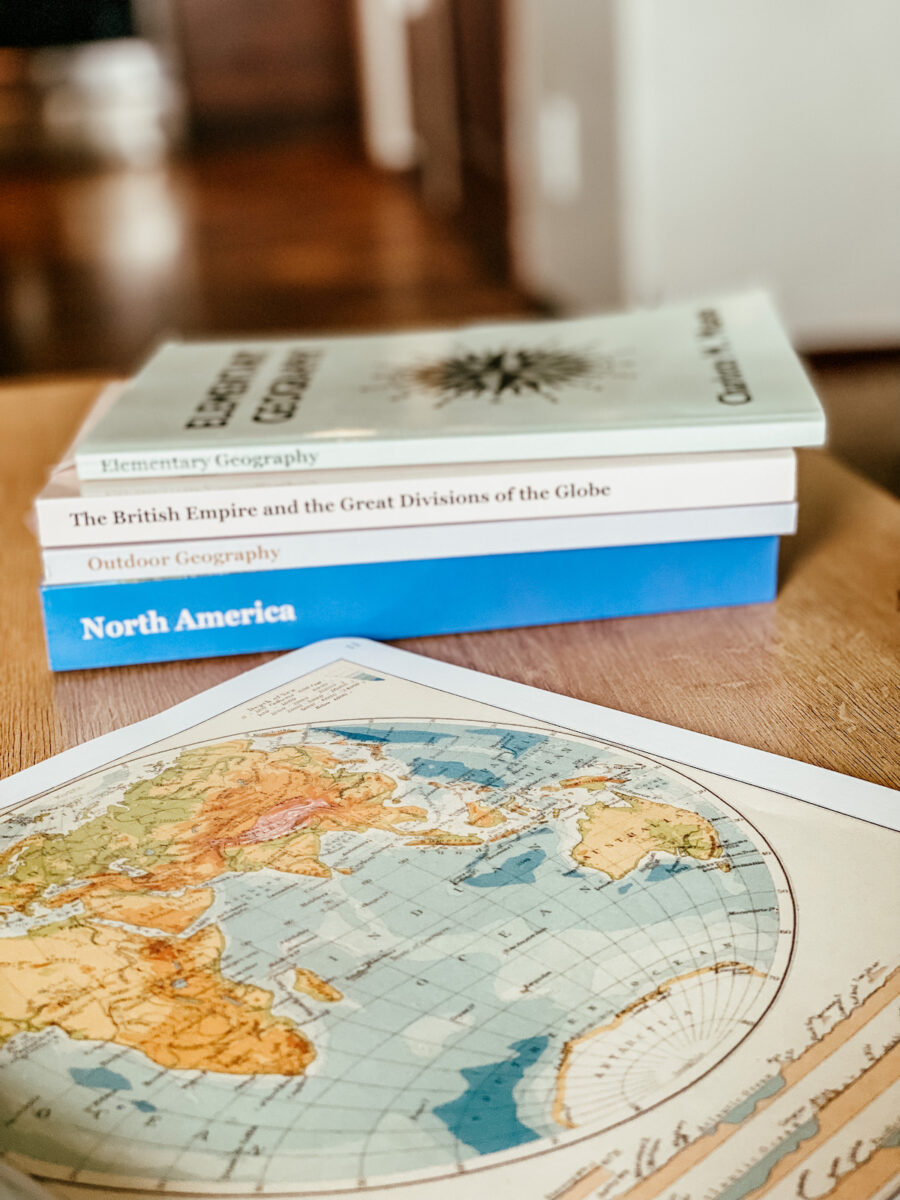 geography books and atlas on a table.