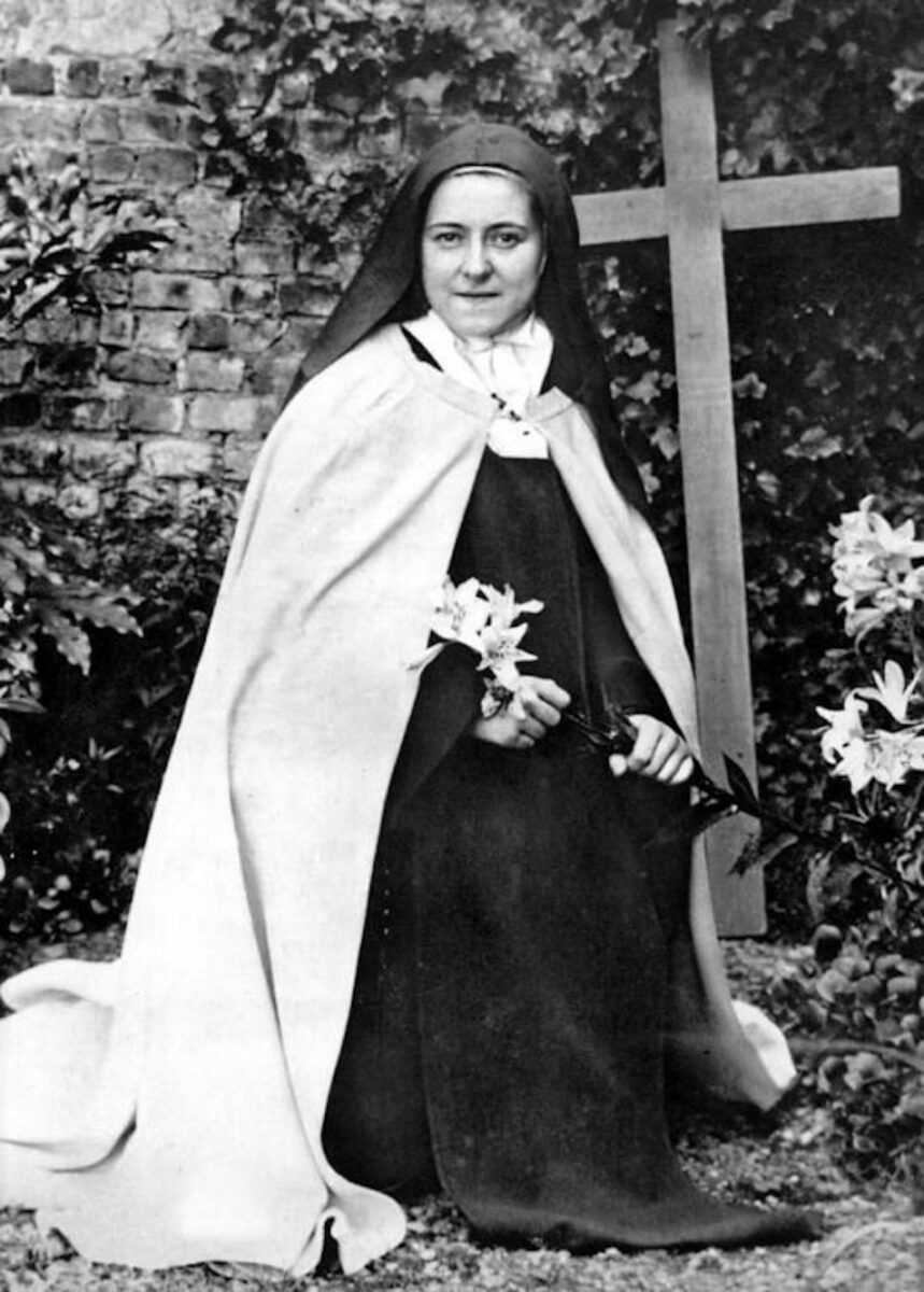St Therese of Lisieux kneeling in the convent courtyard.