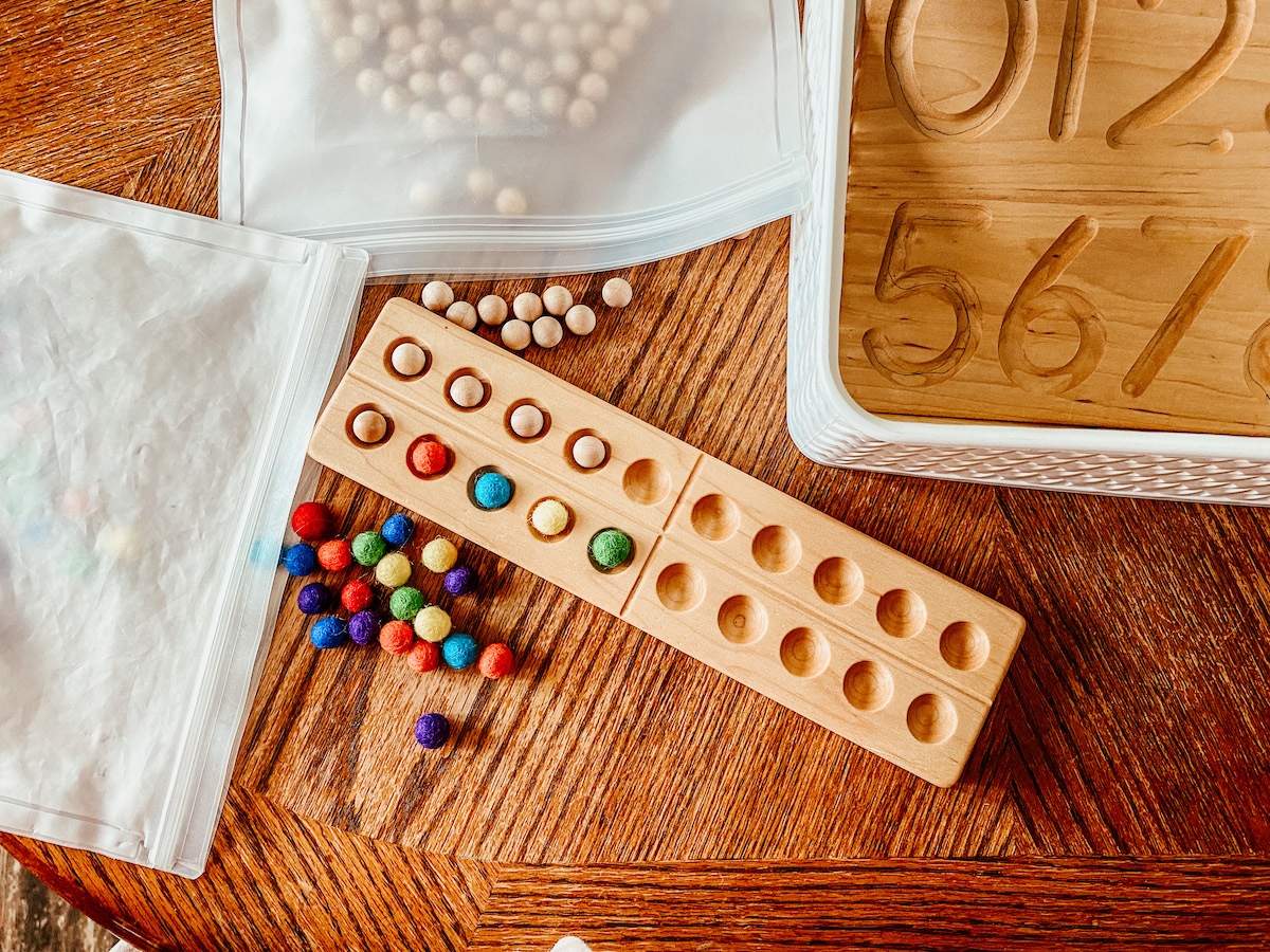 wool & wooden balls on a counting board for preschool math lessons.