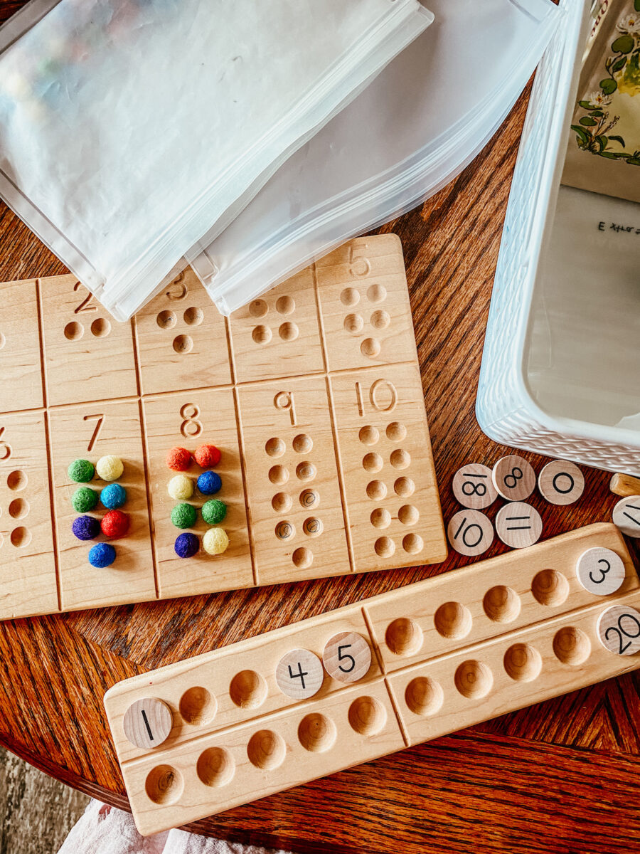 wooden boards with wool balls and number coins for preschool math lessons.