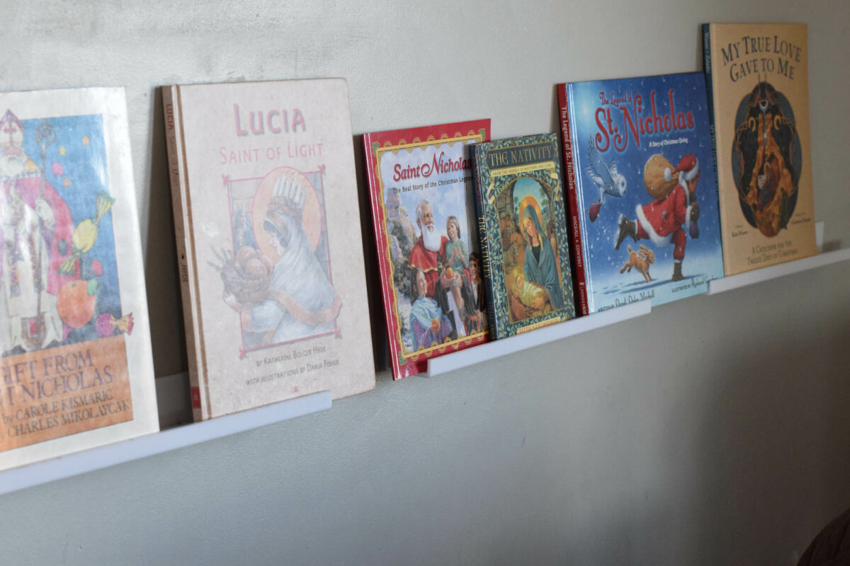 christmas picture books on a white book ledge on the wall. 