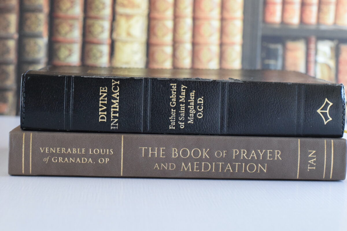 stack of vintage prayer books on a table.