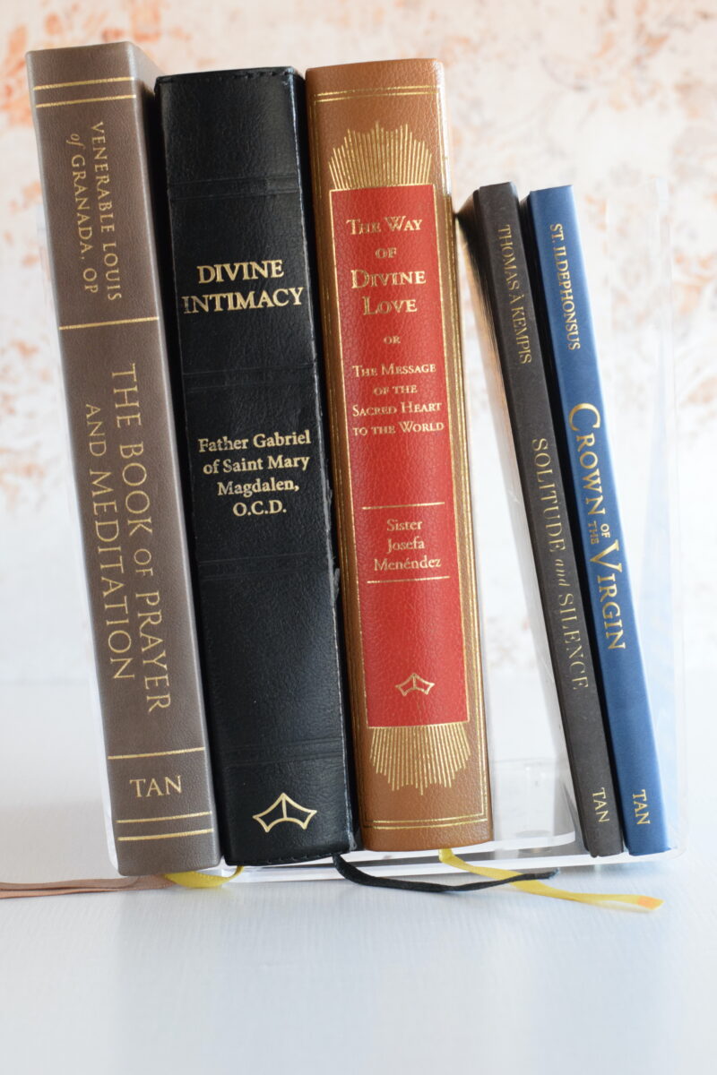 stack of vintage prayer books on a table.