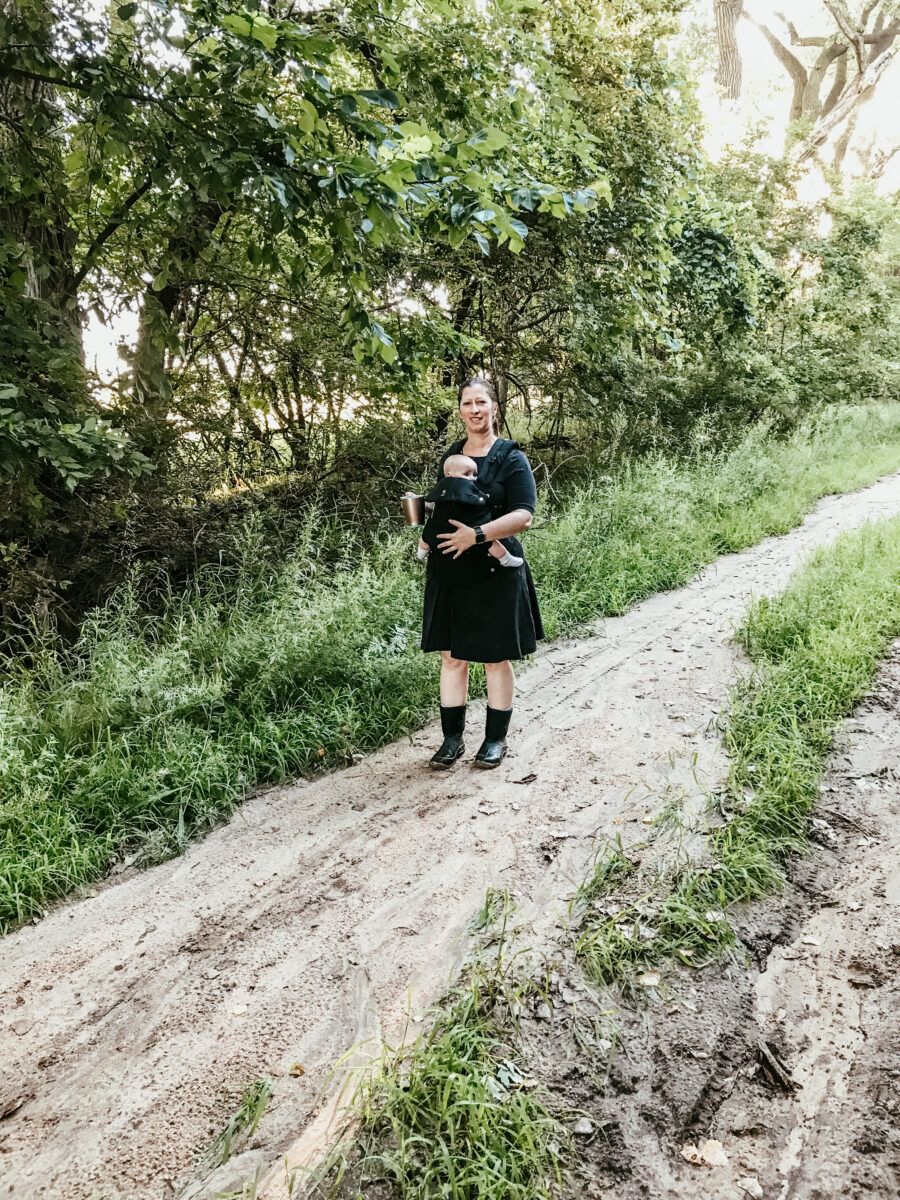 mom walking on trail in while carrying baby in baby carrier. 