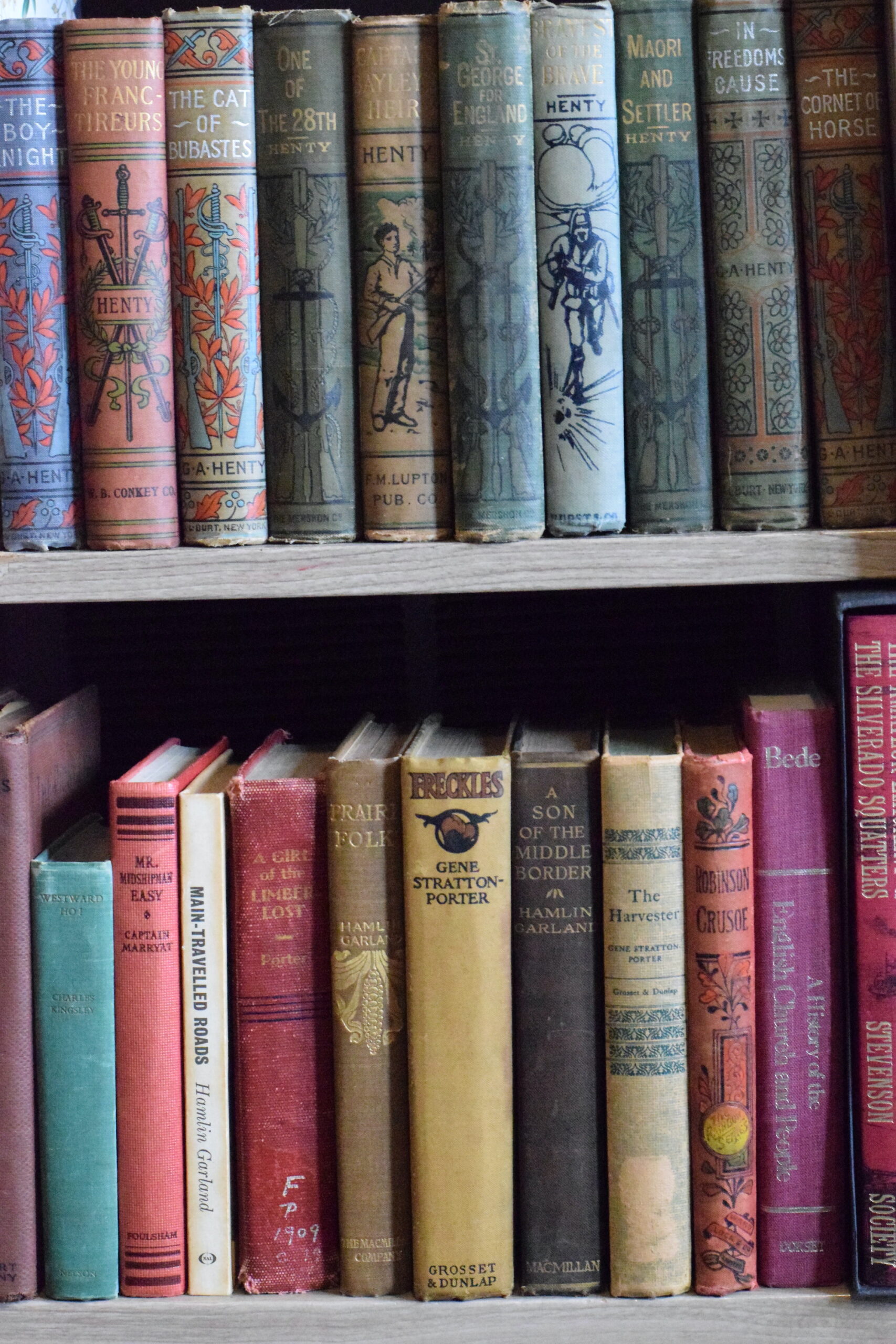 Vintage children’s books in hardcovers on a bookshelf.