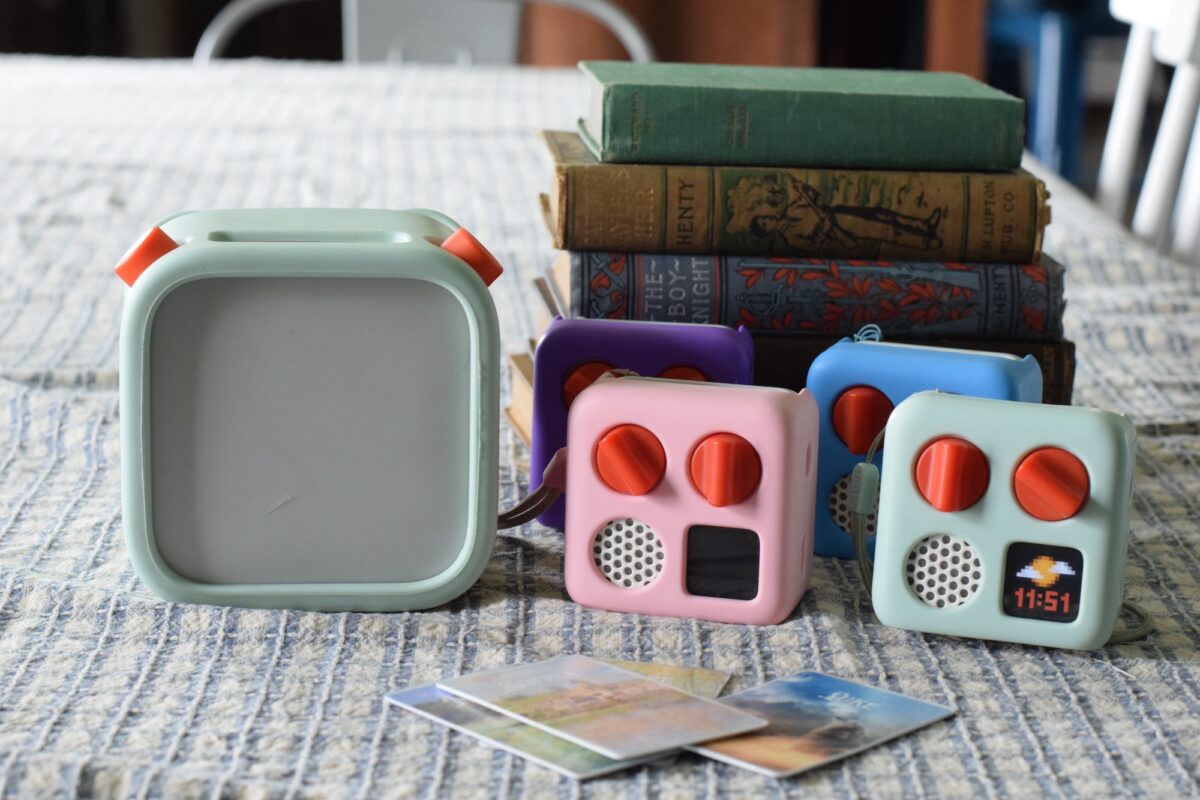 variety of Yoto player and minis with cards and stack of books on a table. 