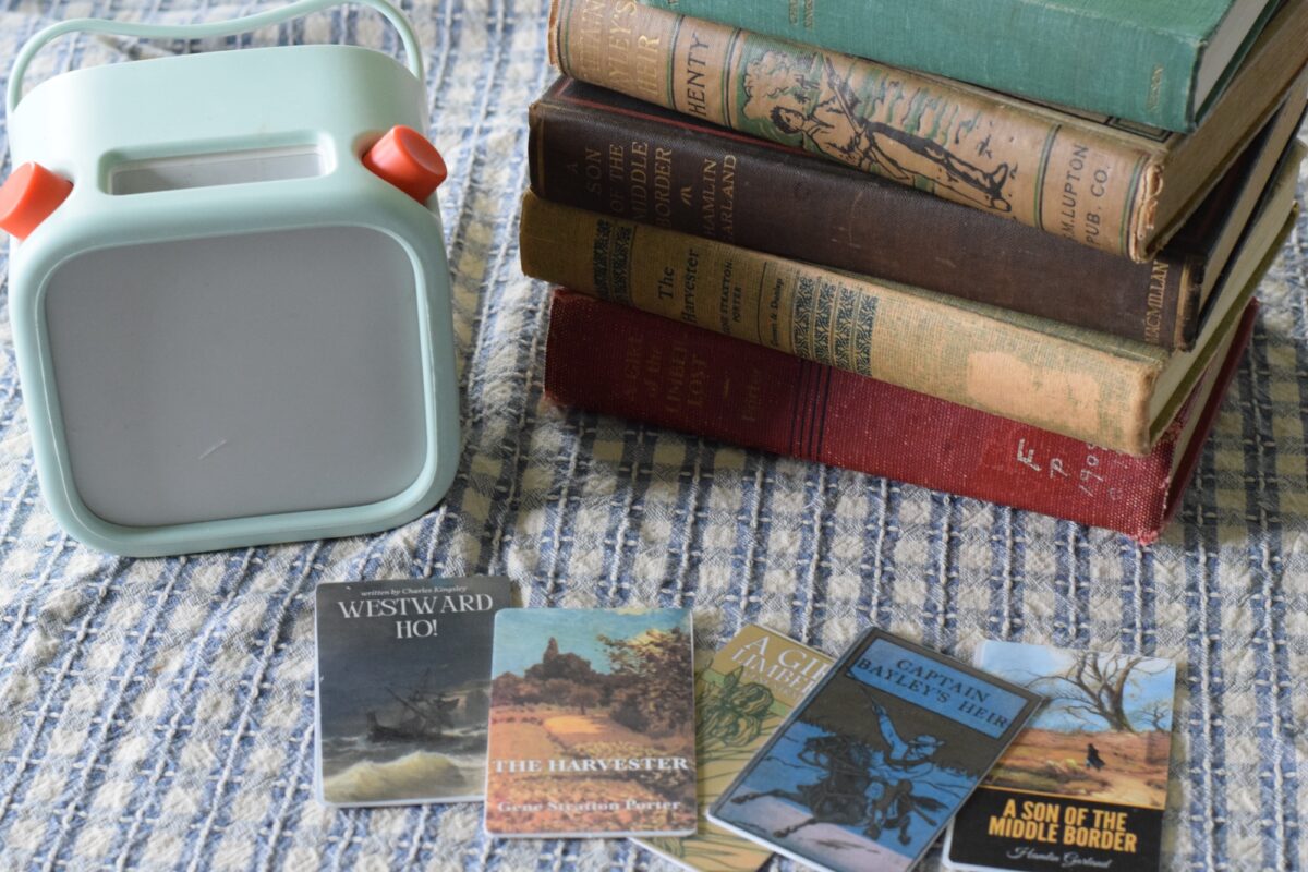 Yoto player with cards and a stack of literature on a table.