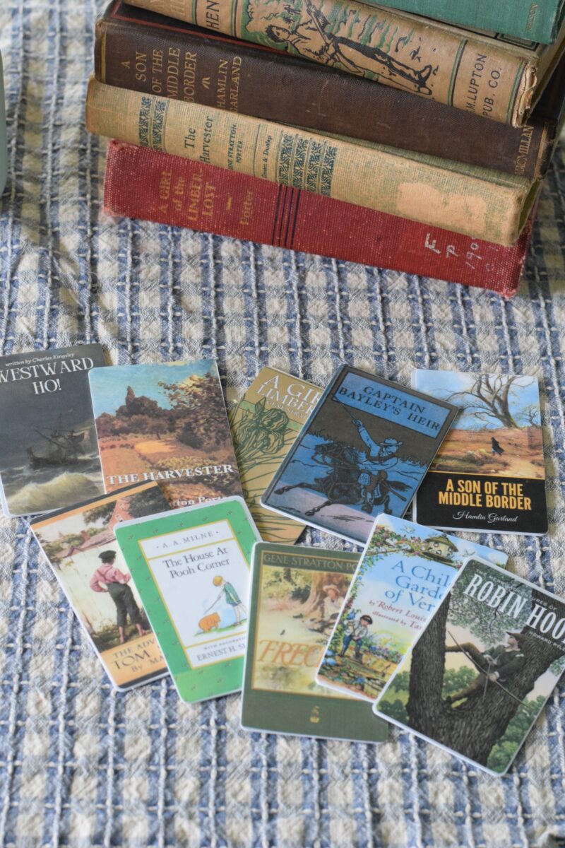 Yoto cards and vintage books stacked on a table. 