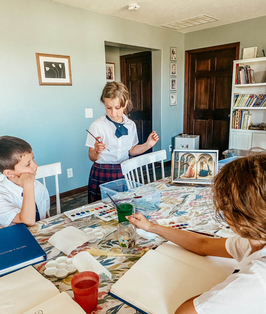 children gathered around the table and looking art art print. 