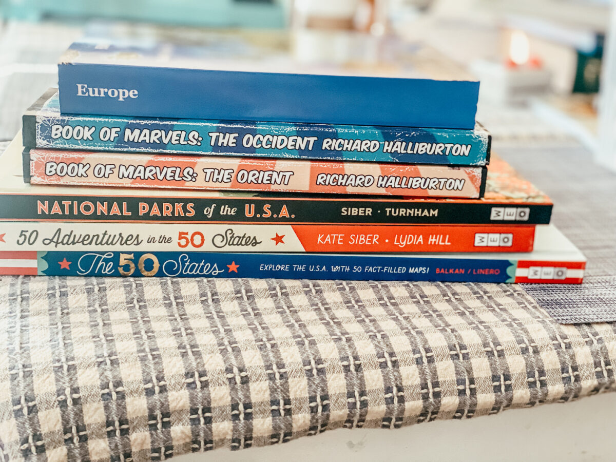 year 6 geography books stacked on a table. 