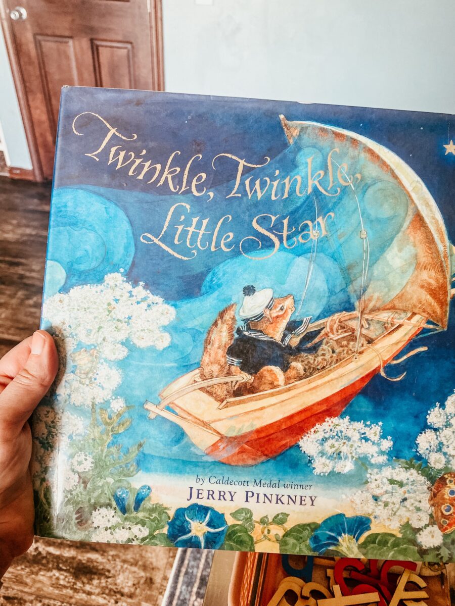 holding a picture book titled "Twinkle, Twinkle, Little Star". 