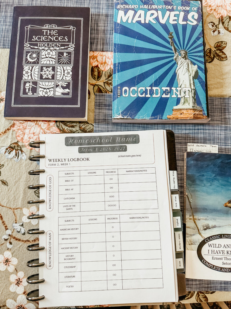 planner open with logbook page and school books stacked around it. 