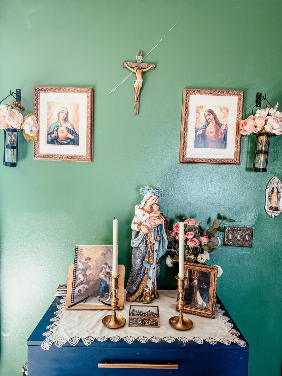 family home altar set up with statue, images, and blessed candles. 